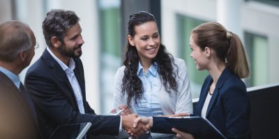 Group of businesspeople having a discussion near staircase in office