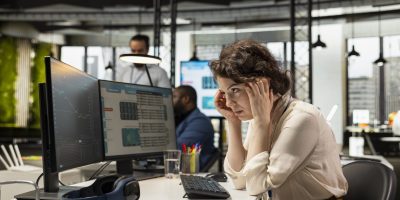 Stressed sad female consultant looks at stock crash trends market fall and worrying about a financial crisis. Businesswoman under pressure due to cryptocurrency price drop, inflation.